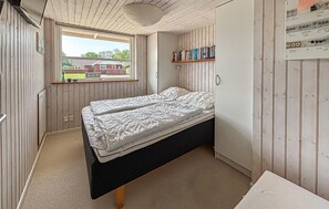 A small bedroom with a single bed, a window with a view of a house, and a bookshelf. - Stunning home in Sjølund with sauna (Sjølund)