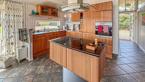 Una cocina moderna con armarios de madera, una isla central y un amplio ventanal.