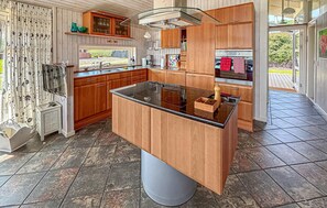 A modern kitchen with wooden cabinets, a central island, and a large window. - Stunning home in Sjølund with sauna (Sjølund)