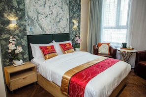 A hotel room with a large bed, a nightstand, a small table, and a chair. - Singala Hotel Ulaanbaatar (Ulaanbaatar)