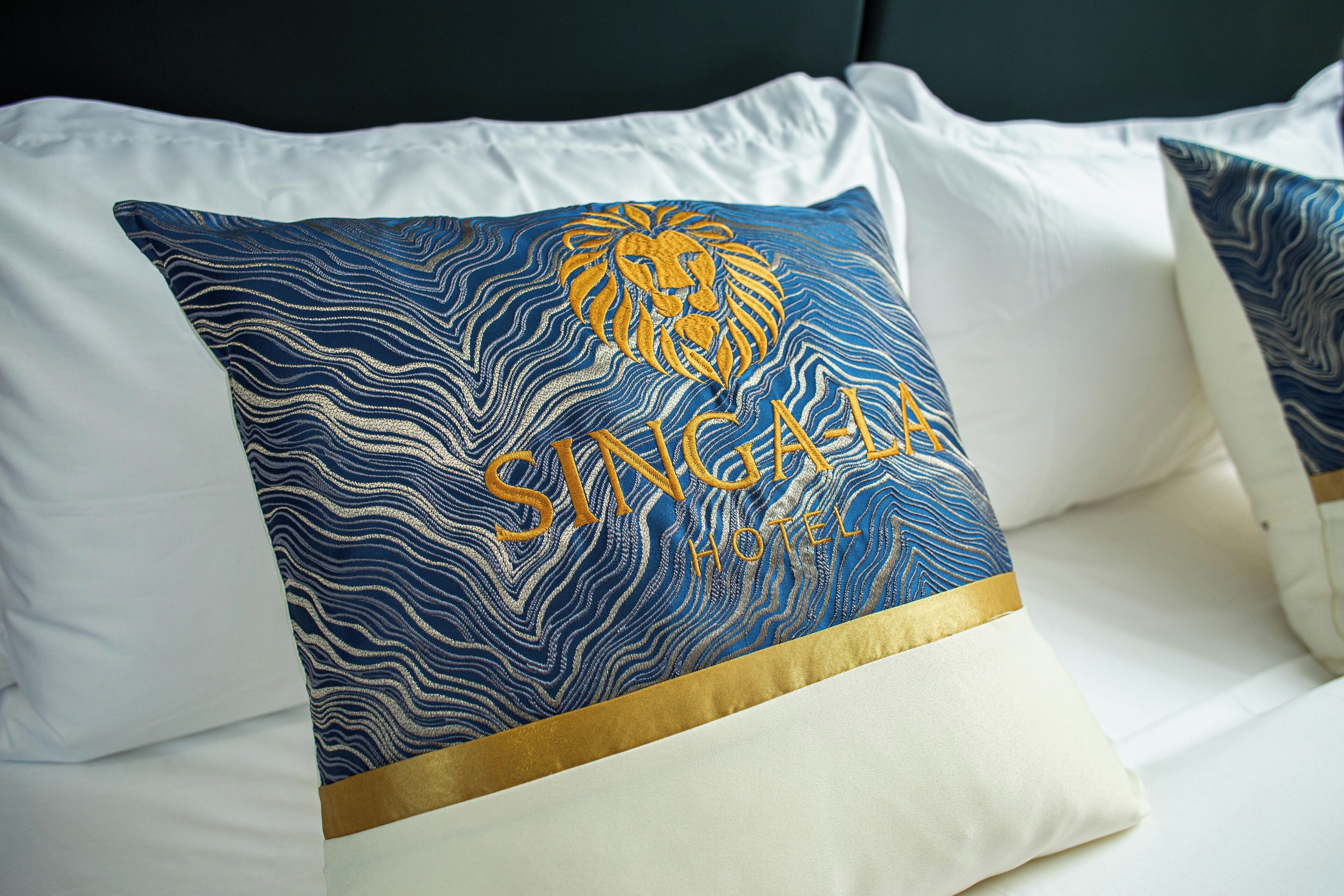 Un coussin orné d’un motif de lion et portant l’inscription « Singha Hotel ».
