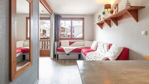 Una stanza accogliente con due letti, un tavolo di legno e un balcone con vista.