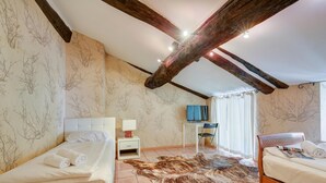 Une chambre à coucher avec un lit, un bureau, une télévision et une grande moquette en fourrure.