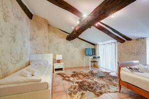 Un dormitorio con una cama, un escritorio, un televisor y una alfombra grande de piel.
