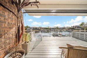 Ein Balkon mit Blick auf einen Yachthafen, eine Ziegelwand und ein Blumentopf.