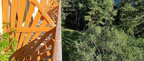 A wooden balcony with a view of a mountain.