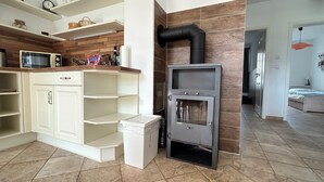 A modern kitchen with a built-in stove, white cabinetry, and a microwave.