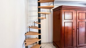 Een hoek met een houten spiraalplank en een houten kast.