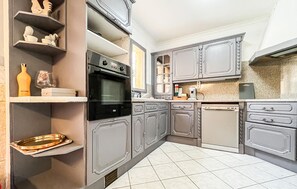 A kitchen with grey cabinets, a black oven, and a white dishwasher. - Amazing home in Vers-Pont-Du-Gard with WiFi (Vers-Pont-Du-Gard)