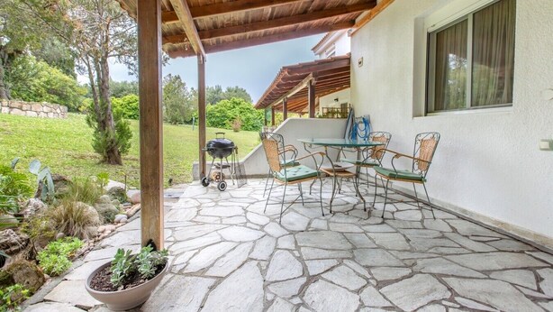A covered patio with stone flooring, outdoor furniture, and a grill. - Possidi Zen Maisonette by RentalsPro (Kassandreia)