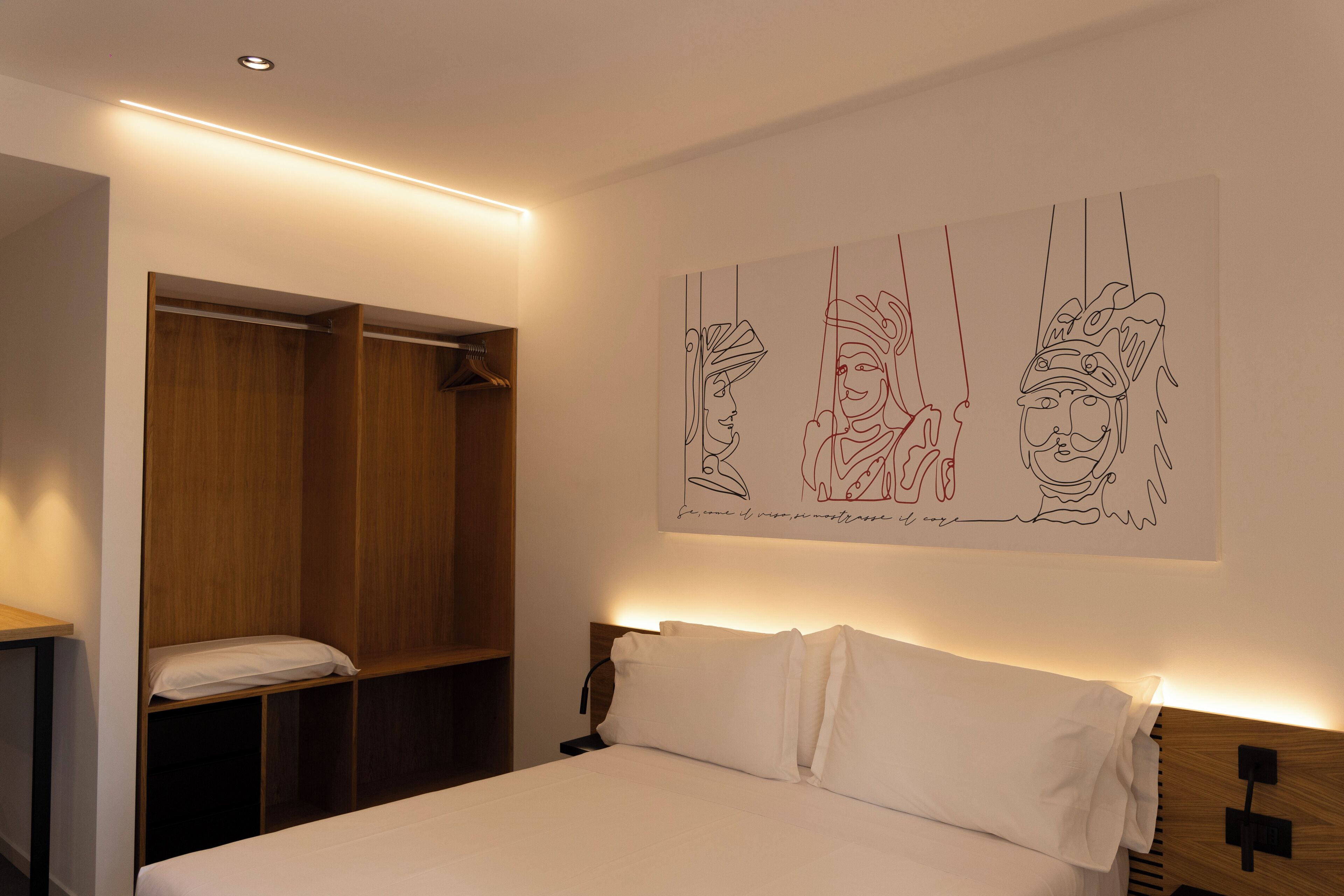 Ein Schlafzimmer mit einem Bett, einem Holzschrank und einem an der Wand hängenden Kunstwerk.