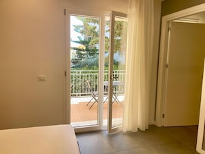 A room with a sliding glass door leading to an outdoor balcony with a table and chairs. - La Dimora Dei Paladini (Bagheria)