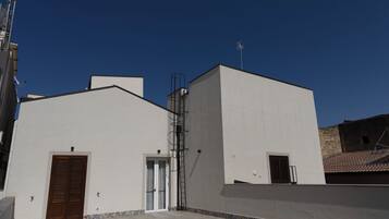 Un edificio con techo plano, una puerta y una ventana.