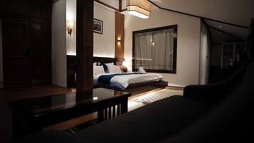 A hotel room with a bed, a nightstand, a lamp, a window with curtains, and a view of the outside.