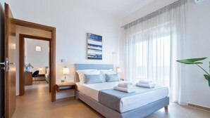 A hotel room with a bed, bedside tables, a mirror, a window with curtains, and a plant. - Villa Anastasia - Private Heated Pol (Chania)