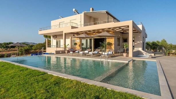A modern two-story house with a swimming pool, outdoor seating, and a covered patio area. - Villa Anastasia - Private Heated Pol (Chania)