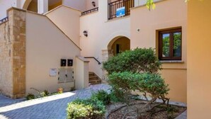 A building with a stone facade, a staircase, and a small garden area. - BF12 Adjacent to Aphrodite Hills - Pool & Terrace (Kouklia)