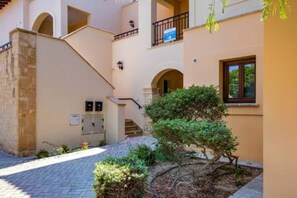 A building with a stone facade, a staircase, and a small garden area. - BF12 Adjacent to Aphrodite Hills - Pool & Terrace (Kouklia)
