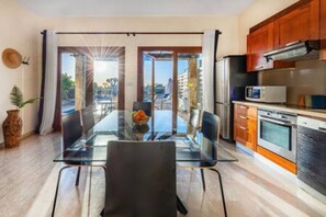 A modern kitchen with wooden cabinets, a microwave, and a stove. - HG07 Adjacent to Aphrodite Hill - Pool & Terrace (Kouklia)