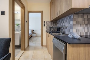 Une cuisine moderne avec des meubles en bois, un lave-vaisselle et un pare-feu en carrelage.
