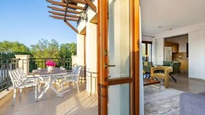 Un interior moderno con comedor, cocina y vistas al exterior.