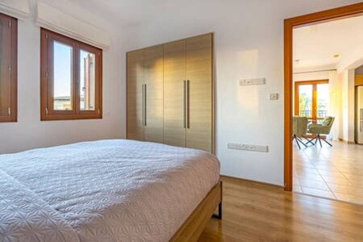 Un dormitorio con cama, armario y vistas al exterior.