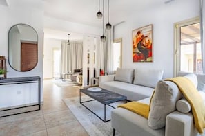Ein stilvolles Wohnzimmer mit einer Couch, einem Couchtisch und Kunstwerken an der Wand.