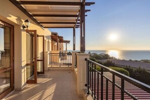Ein Balkon mit Meerblick, einer Pergola und einem Geländer.
