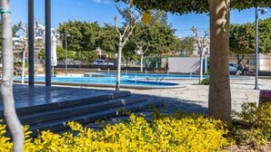 A pool area with steps leading to the water, surrounded by trees and a clear sky. - Olga Apt 1 - 1bdr apartment on ground floor (Limassol)