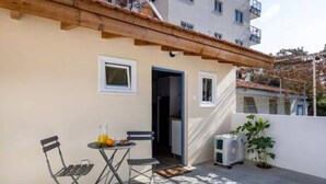 Ein Balkon mit Tisch, Stühlen und einem kleinen Blumentopf.
