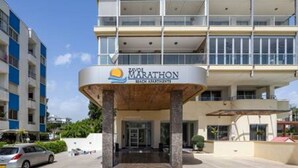 L’entrée d’un hôtel, avec une enseigne indiquant : « MARATHON BEACH APARTMENTS ».