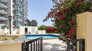 Une piscine, un portail et un bâtiment doté de balcons.