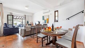 Uma cozinha moderna com uma mesa de jantar posta para dois, um sofá e uma escada.