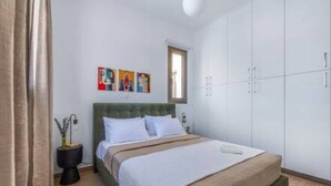 Une chambre à coucher avec un lit, une armoire et une fenêtre.