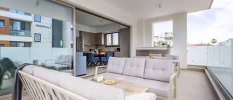 A modern apartment with a balcony, a dining area, and a kitchen.