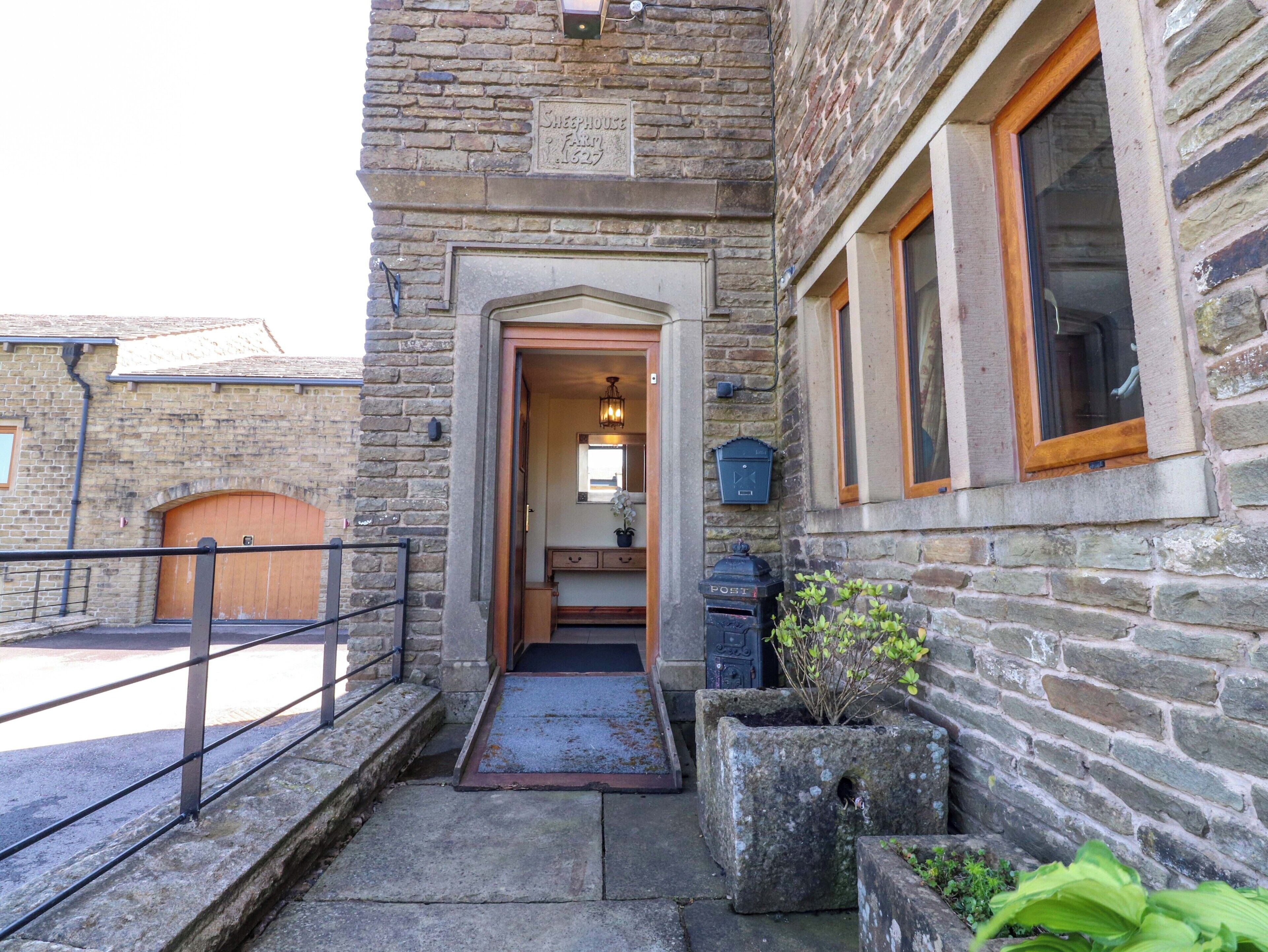 A stone building with a wooden door, a small porch, and a window with a wooden frame.