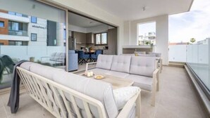 Ein modernes Apartment mit Balkon, Essbereich und Küche.