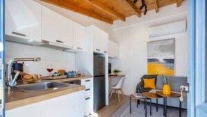 A compact kitchen with white cabinets, a wooden countertop, and a built-in refrigerator. - Olga Apt 4 - lovely studio on ground floor (Limassol)