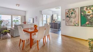Interior moderno com área de refeições, cozinha e sala de estar.