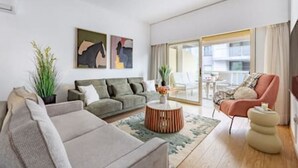 Uma sala de estar moderna com sofá, poltrona e mesa de centro.