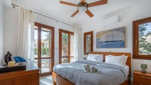 A bedroom with a bed, a desk, a chair, a ceiling fan, and a window with a view. - BK02 Adjacent to Aphrodite Hills – Pool & Sea View (Kouklia)