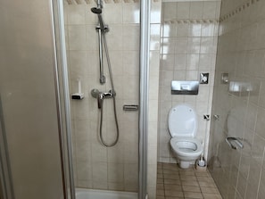 A bathroom with a glass-enclosed shower, a toilet, and a bidet. - defaultName (Wien)