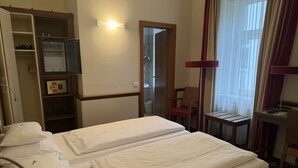 A hotel room with two beds, a wardrobe, a desk, and a mirror. - Hotel Jäger Comfort Double Room (Wien)