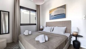 Ein Hotelzimmer mit Bett, Fenster, einem Gemälde und einem Nachttisch.