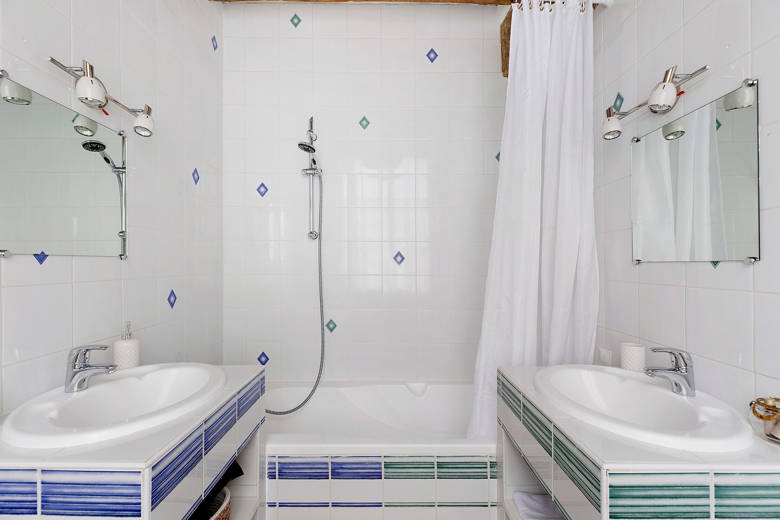Un baño con dos lavamanos, una ducha y un espejo.