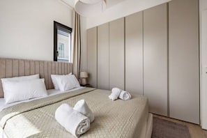 Une chambre d’hôtel avec un lit, une table de chevet, une armoire et une fenêtre.
