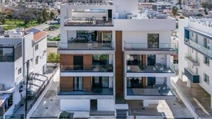 Un edificio moderno de varios pisos con balcones, ventanas amplias y techo plano.