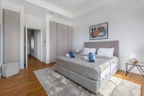 Ein modernes Schlafzimmer mit einem Bett, Nachttischen und einem Bild an der Wand.