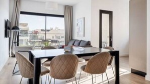 Una moderna camera d'hotel con zona pranzo, ampie finestre e vista sulla città.