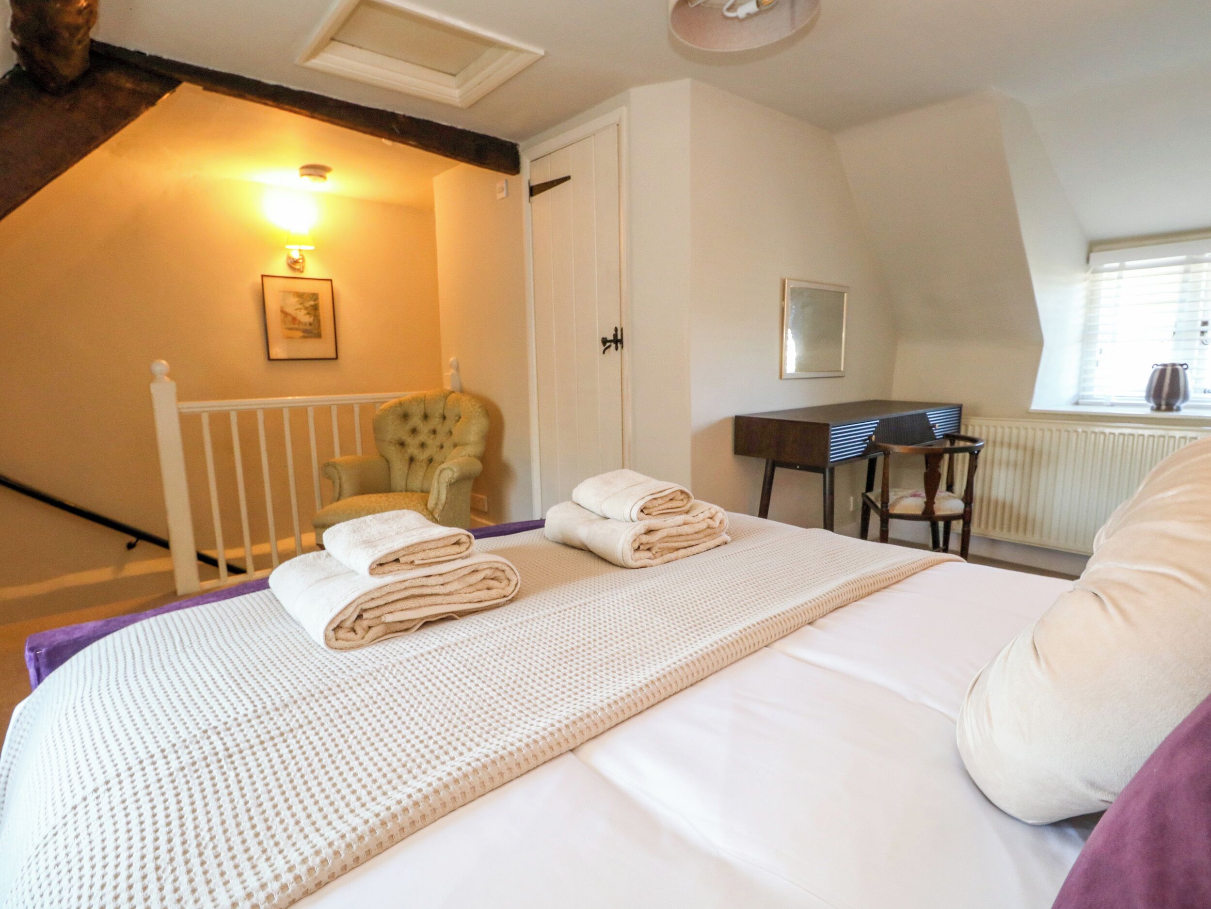 Une chambre à coucher avec un lit, une chaise, un bureau et un radiateur.